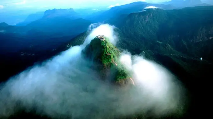 Pilgrims climbing the illuminated stairway of Adam's Peak at dawn
